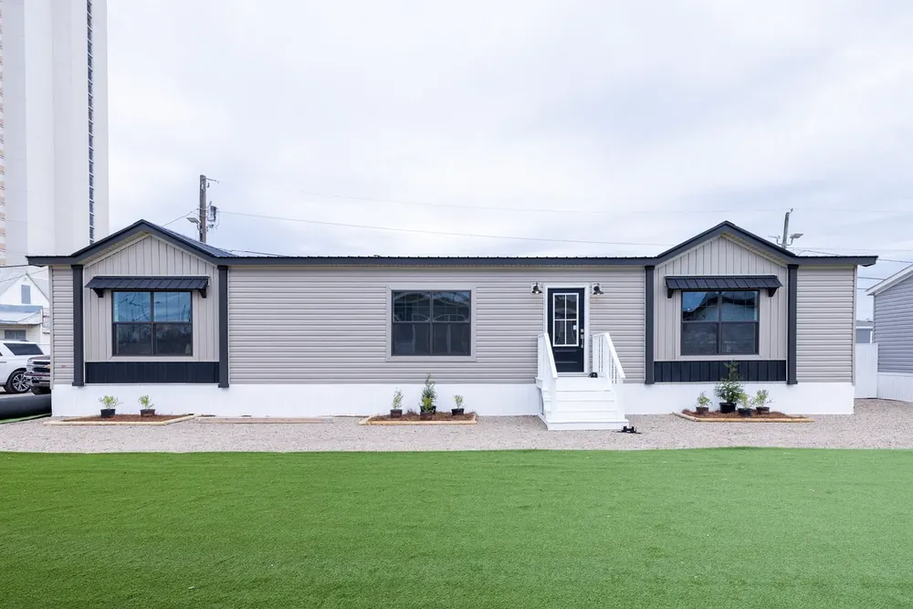 Buccaneer Anna Fae double-wide with dark trim and a white front porch